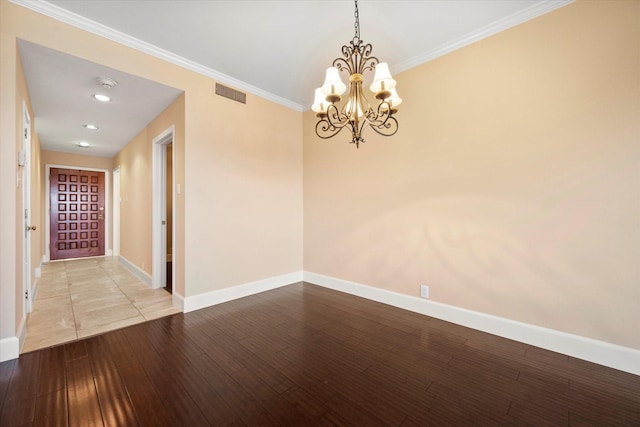 empty room featuring ornamental molding, light hardwood / wood-style flooring, and a notable chandelier