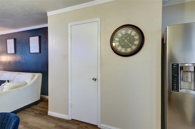 bedroom featuring crown molding, wood-type flooring, and stainless steel fridge