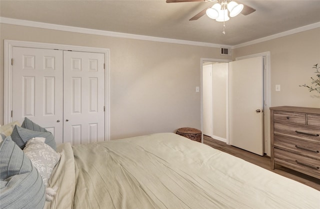 bedroom featuring dark hardwood / wood-style flooring, ornamental molding, a closet, and ceiling fan