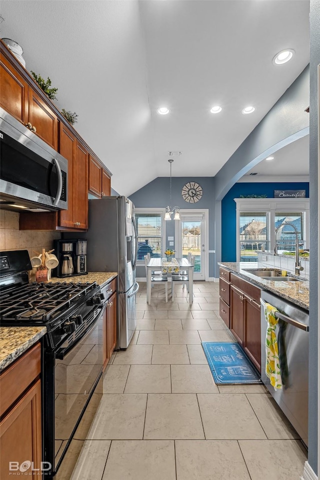 kitchen featuring pendant lighting, light tile patterned floors, sink, appliances with stainless steel finishes, and light stone countertops