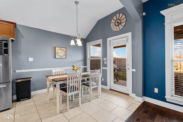 tiled dining area featuring lofted ceiling and a chandelier