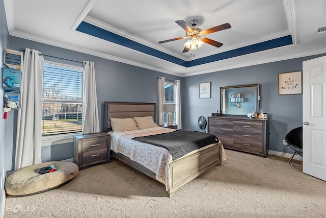 carpeted bedroom featuring ornamental molding, ceiling fan, and a tray ceiling