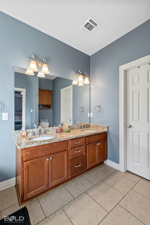 bathroom with tile patterned flooring, vanity, and toilet