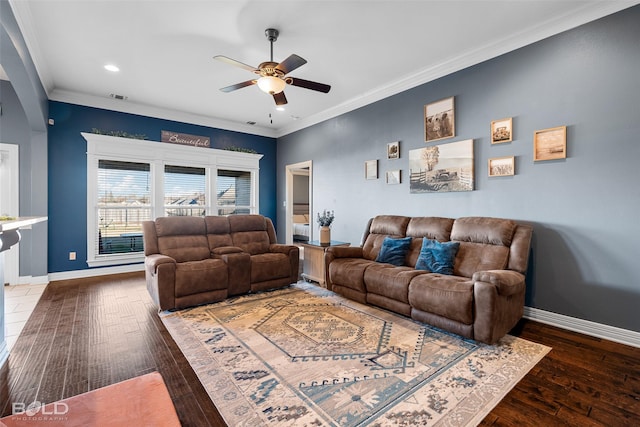 living room with dark wood-type flooring, ceiling fan, and ornamental molding