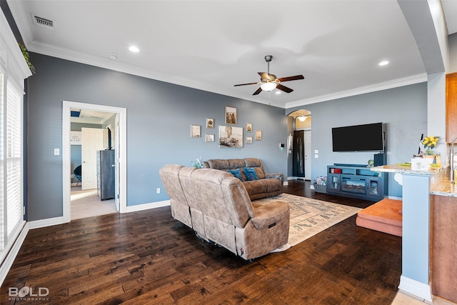 living room featuring crown molding, dark wood-type flooring, and ceiling fan