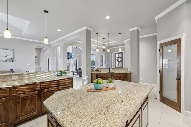 kitchen featuring light stone counters, hanging light fixtures, and a center island