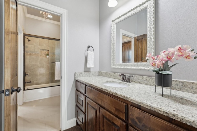 bathroom with tiled shower / bath combo, vanity, and ornamental molding