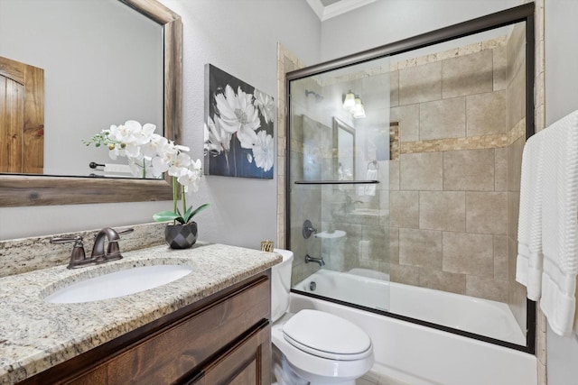 full bathroom featuring vanity, bath / shower combo with glass door, and toilet