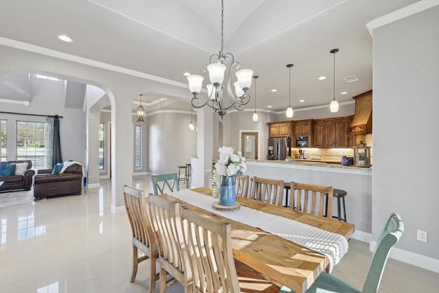 dining space with crown molding, lofted ceiling, a chandelier, and light tile patterned floors