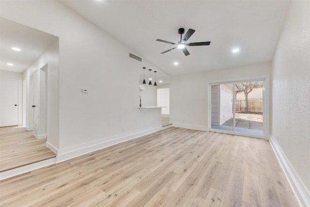 unfurnished living room with vaulted ceiling, light hardwood / wood-style floors, and ceiling fan