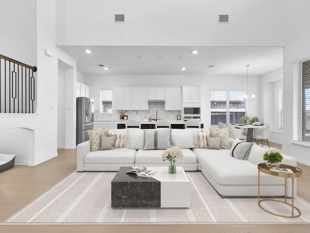 living room with light hardwood / wood-style floors and a chandelier