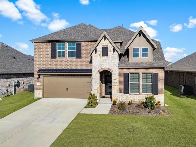 view of front facade with cooling unit, a garage, and a front lawn