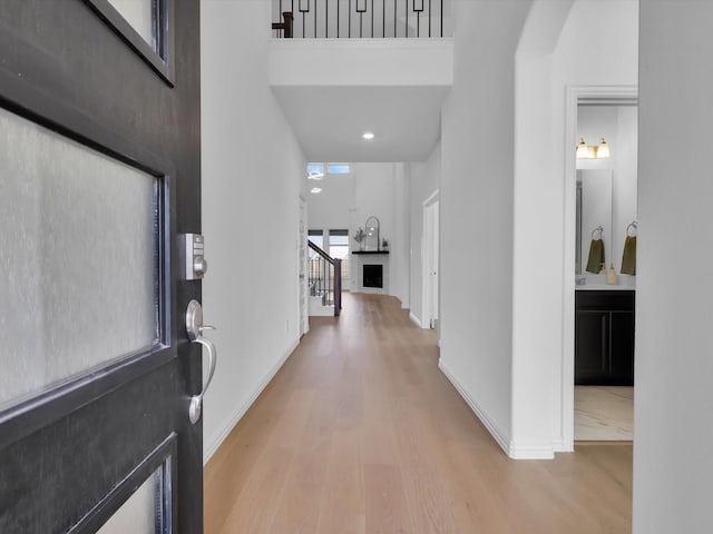 entrance foyer featuring stairway, wood finished floors, a towering ceiling, and baseboards