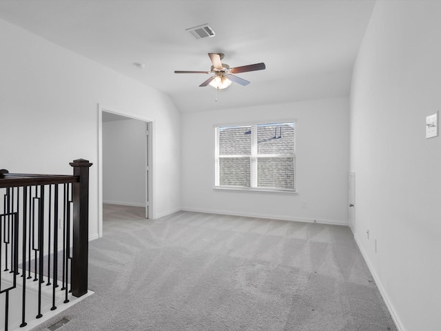 empty room featuring lofted ceiling, light carpet, and ceiling fan