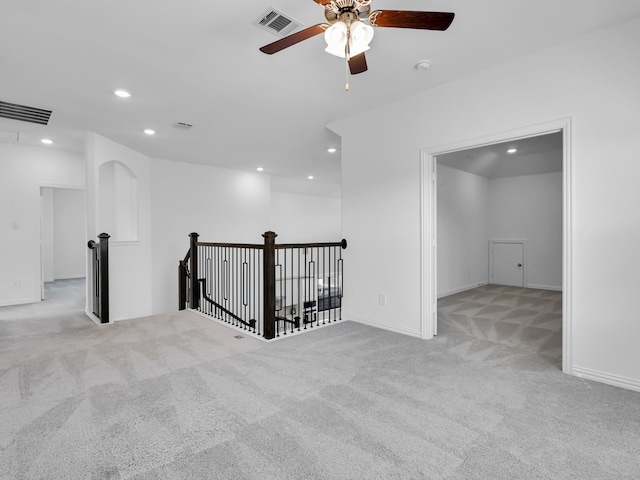 spare room featuring light colored carpet and ceiling fan