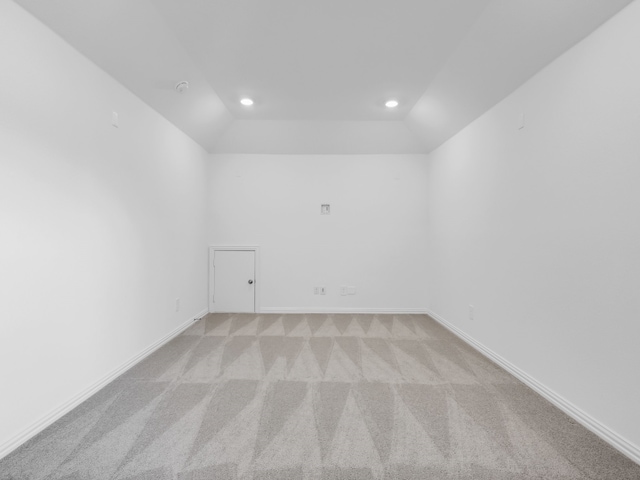 empty room featuring vaulted ceiling and light carpet