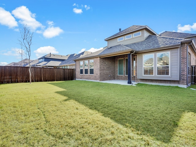 back of house featuring a patio and a lawn