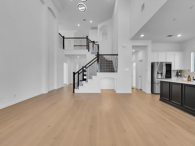 living room featuring a high ceiling and light wood-type flooring