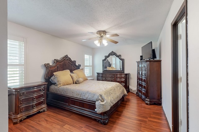 bedroom featuring ceiling fan, dark hardwood / wood-style floors, and a textured ceiling