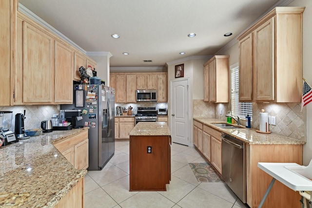 kitchen featuring a kitchen island, light stone countertops, appliances with stainless steel finishes, and light brown cabinetry