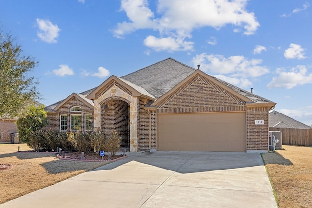 view of front of home with a garage and central AC unit