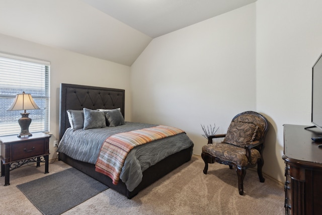 bedroom featuring lofted ceiling and light carpet