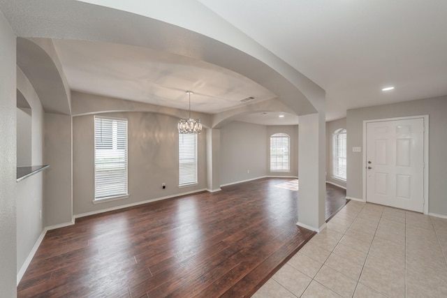 entrance foyer with light hardwood / wood-style flooring and a notable chandelier