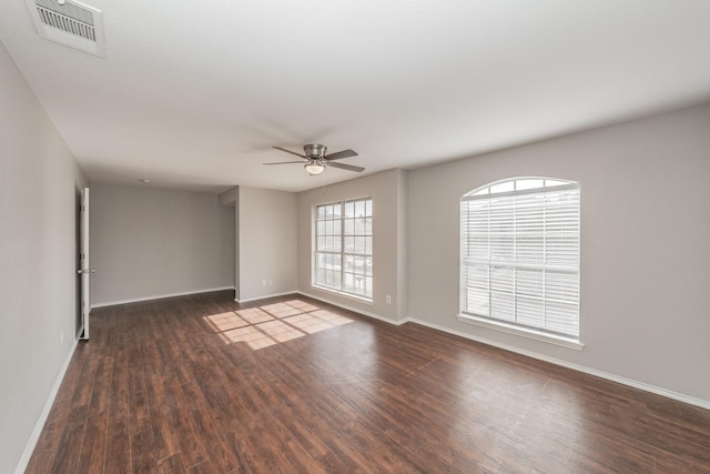 spare room with dark wood-type flooring and ceiling fan