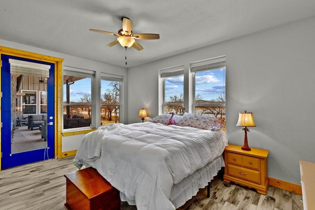 bedroom featuring multiple windows, ceiling fan, and light wood-type flooring