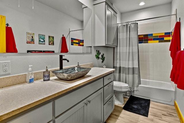 full bathroom with vanity, toilet, shower / tub combo, and hardwood / wood-style floors