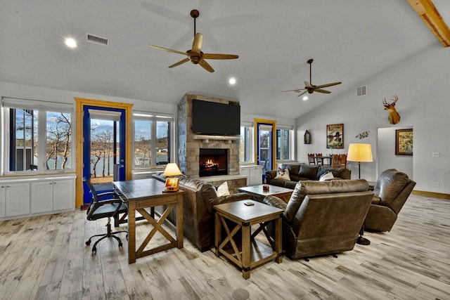 living room with high vaulted ceiling, a fireplace, light hardwood / wood-style floors, and ceiling fan