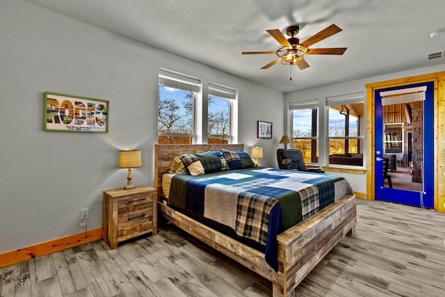 bedroom with a textured ceiling, ceiling fan, and light wood-type flooring