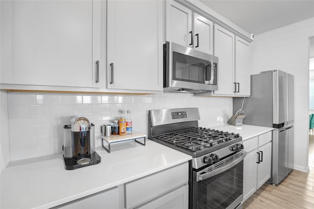 kitchen with tasteful backsplash, light hardwood / wood-style flooring, and appliances with stainless steel finishes