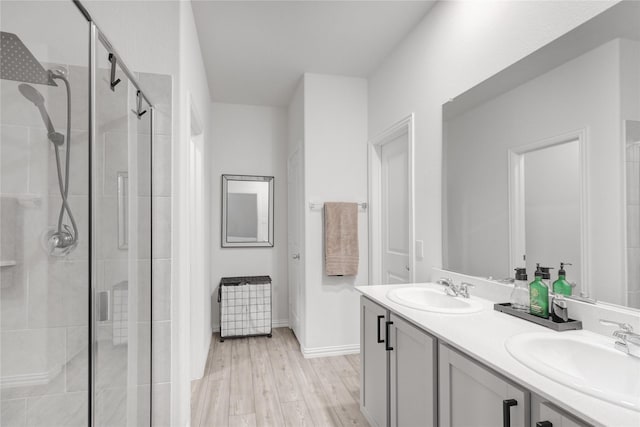 bathroom with hardwood / wood-style flooring, vanity, and a shower with door