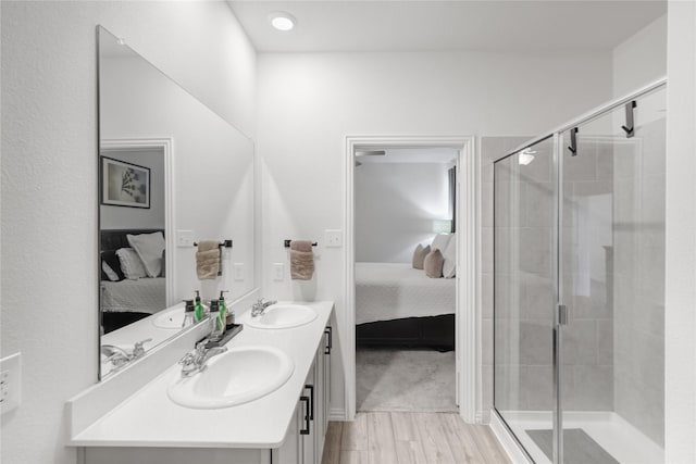 bathroom featuring wood-type flooring, vanity, and a shower with shower door