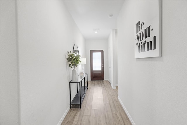 corridor with light hardwood / wood-style flooring