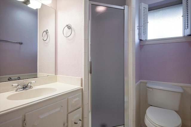 bathroom with vanity, a shower with shower door, and toilet