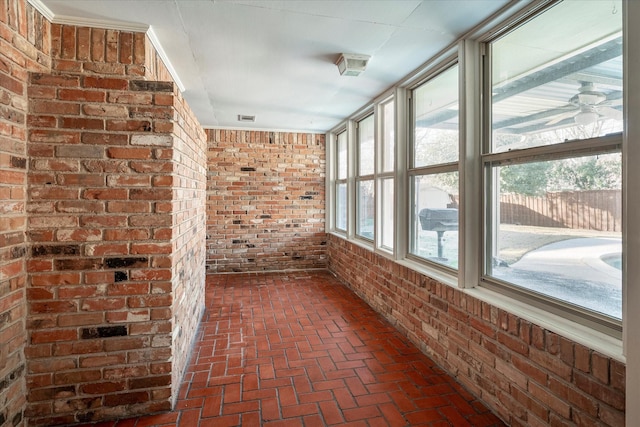 unfurnished sunroom with a wealth of natural light and ceiling fan