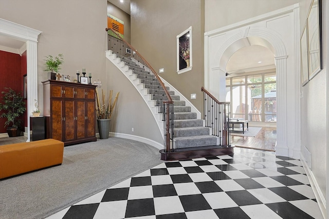 foyer entrance with a towering ceiling and ornamental molding