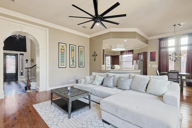 living room featuring ornamental molding, ceiling fan with notable chandelier, and hardwood / wood-style floors