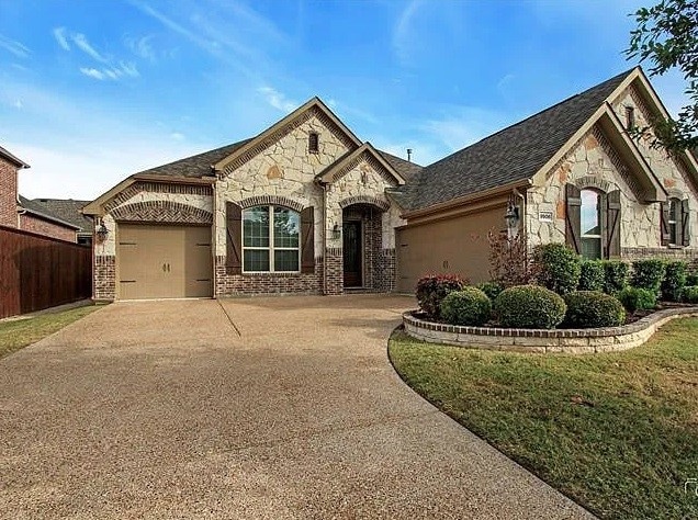 french country style house with a garage and a front yard