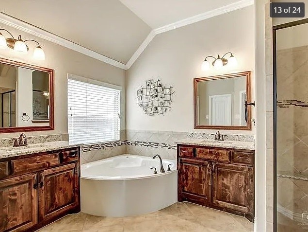 bathroom with crown molding, tile patterned flooring, vanity, plus walk in shower, and vaulted ceiling