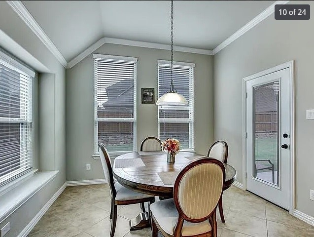 dining space with lofted ceiling, light tile patterned floors, and ornamental molding