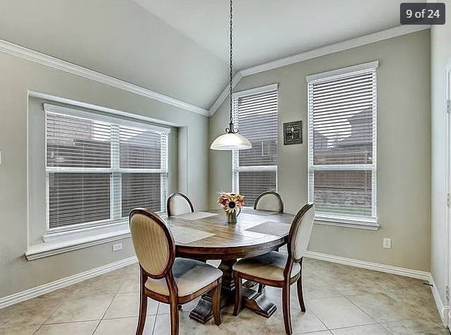 dining space featuring crown molding, vaulted ceiling, a healthy amount of sunlight, and light tile patterned flooring