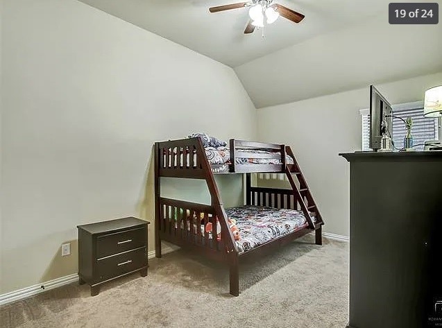 bedroom with vaulted ceiling, light colored carpet, and ceiling fan