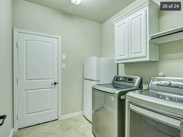 laundry room with cabinets and washer and clothes dryer