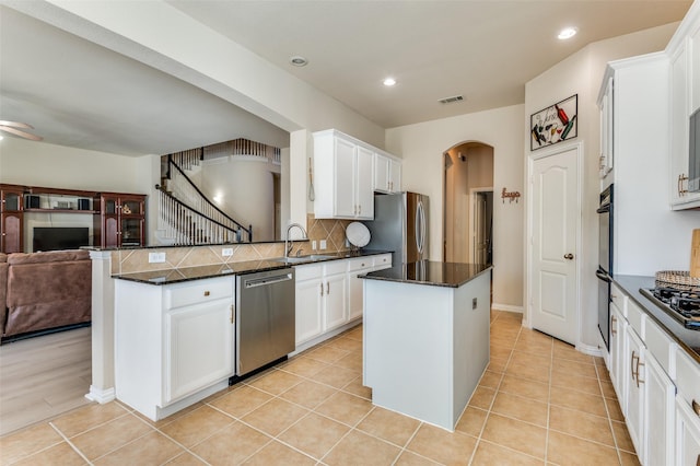 kitchen with sink, white cabinetry, tasteful backsplash, a center island, and appliances with stainless steel finishes