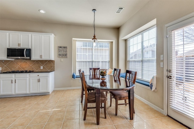 tiled dining space featuring plenty of natural light