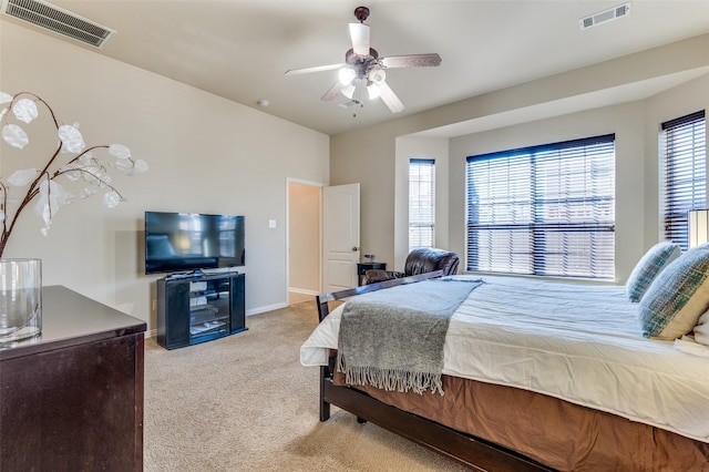 bedroom with ceiling fan, multiple windows, and light carpet