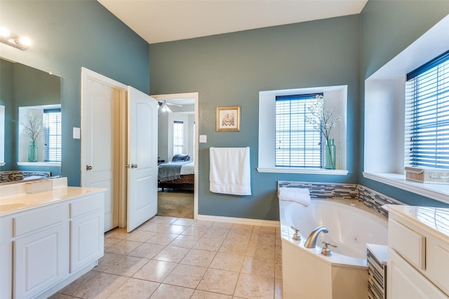 bathroom with tile patterned flooring, vanity, ceiling fan, and a tub to relax in